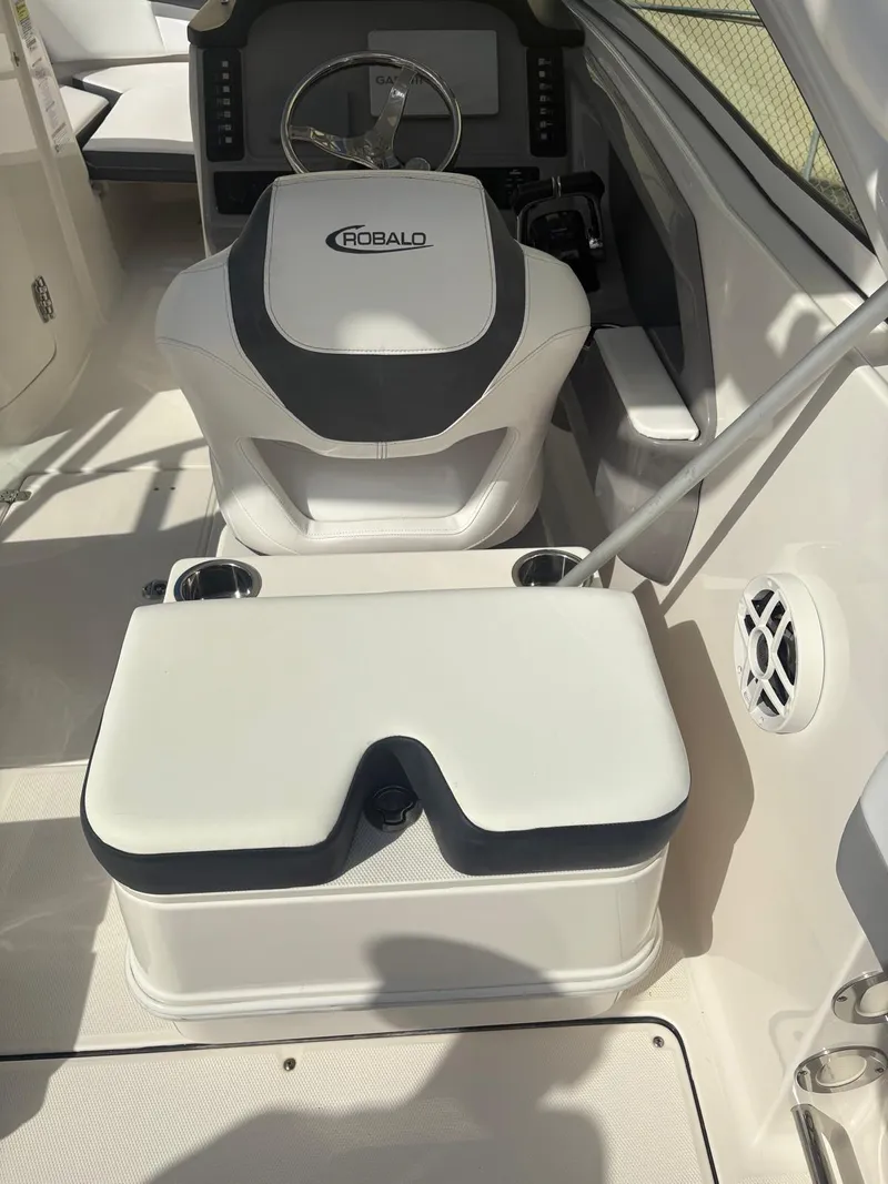 Slide: The Image of Storage compartment on 2021 Robalo R247 Dual Console boat with cleaning supplies and stereo system. - 13