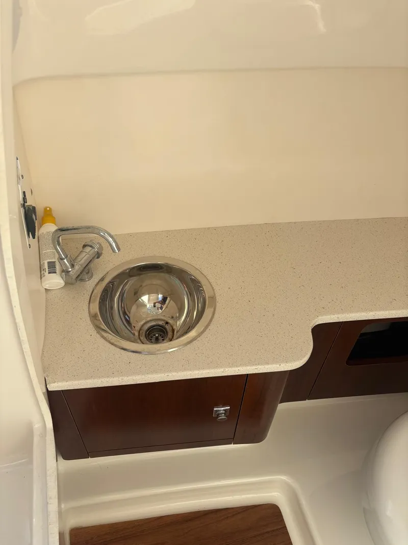 Slide: The Image of 2021 Robalo R247 Dual Console boat with Yamaha engine, covered and docked outdoors. - 6