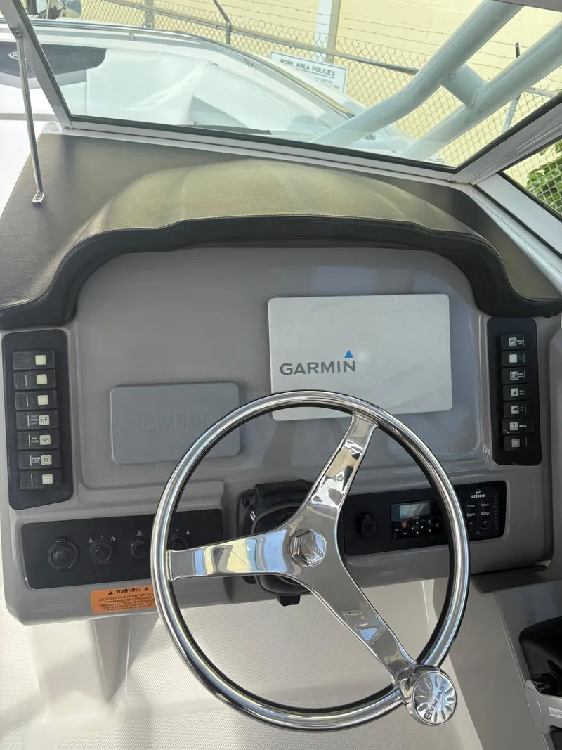 Slide: The Image of 2021 Robalo R247 Dual Console boat interior with white cushioned seating and speakers. - 8