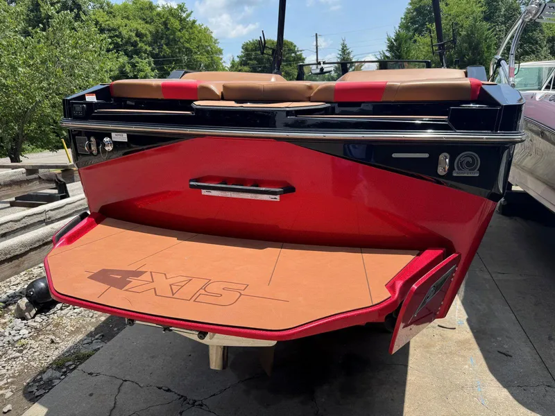 Slide: The Image of 2022 Axis T250 boat with red exterior and tan seating, docked outdoors. - 12