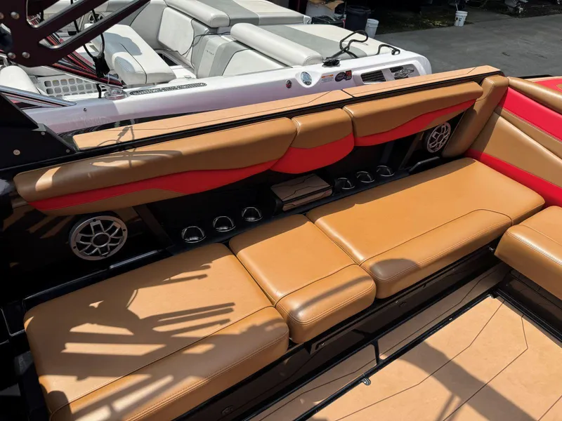 Slide: The Image of Luxurious tan and red seating on a 2022 Axis T250 boat, featuring built-in speakers. - 15