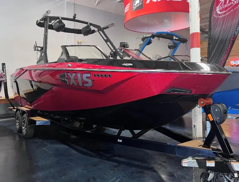 Slide: The Image of 2022 Axis T250 boat in showroom, red and black design, on trailer. - 2