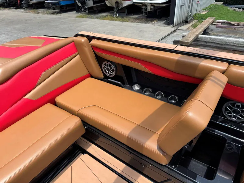 Slide: The Image of Luxurious tan and red seating on a 2022 Axis T250 boat, featuring cup holders and speakers. - 21