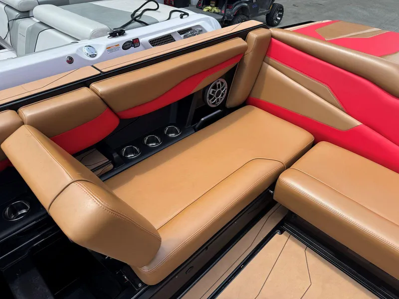 Slide: The Image of 2022 Axis T250 boat interior with tan and red seating, cup holders, and speaker. - 22