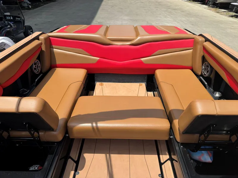 Slide: The Image of 2022 Axis T250 boat interior with tan and red seating, featuring built-in speakers. - 23