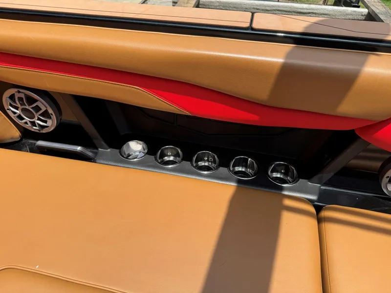 Slide: The Image of 2022 Axis T250 boat interior with tan and red upholstery, cup holders, and speaker. - 25
