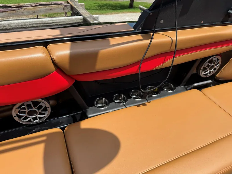 Slide: The Image of 2022 Axis T250 boat interior with tan and red seating, cup holders, and speakers. - 26