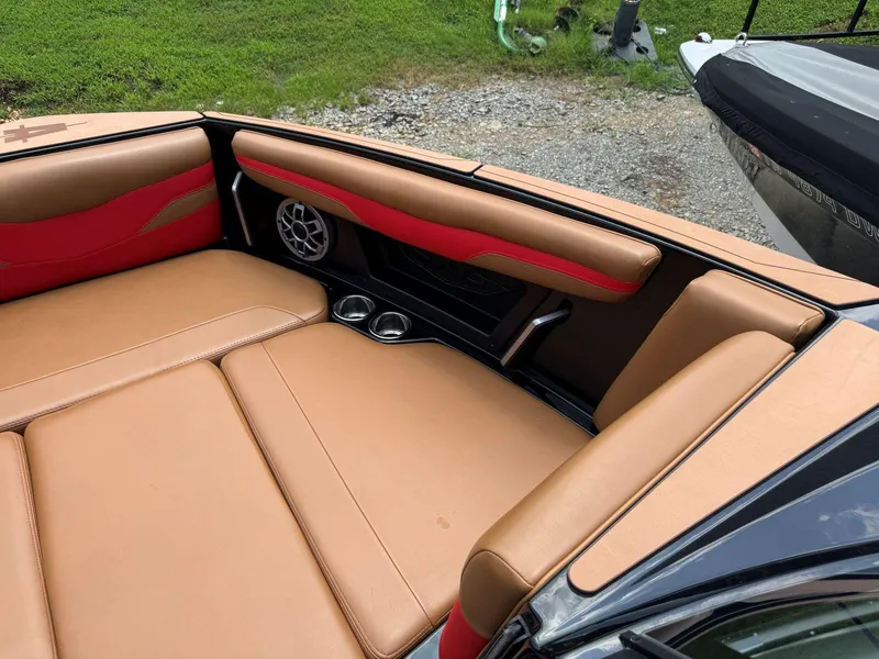 Slide: The Image of 2022 Axis T250 boat interior with tan and red seating, speaker, and cup holders. - 28