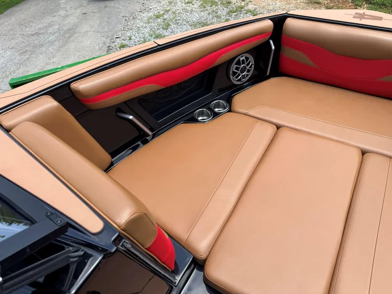 Slide: The Image of 2022 Axis T250 boat interior with tan and red seating, cup holders, and speaker. - 29