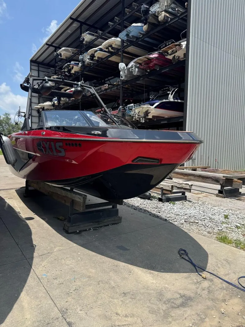Slide: The Image of Red 2022 Axis T250 boat on a dock, surrounded by stacked boats in a storage facility. - 6