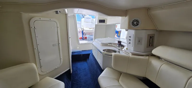 Slide: The Image of Interior of 2007 Fountain 42 Executioner boat with white seating and compact kitchenette. - 24