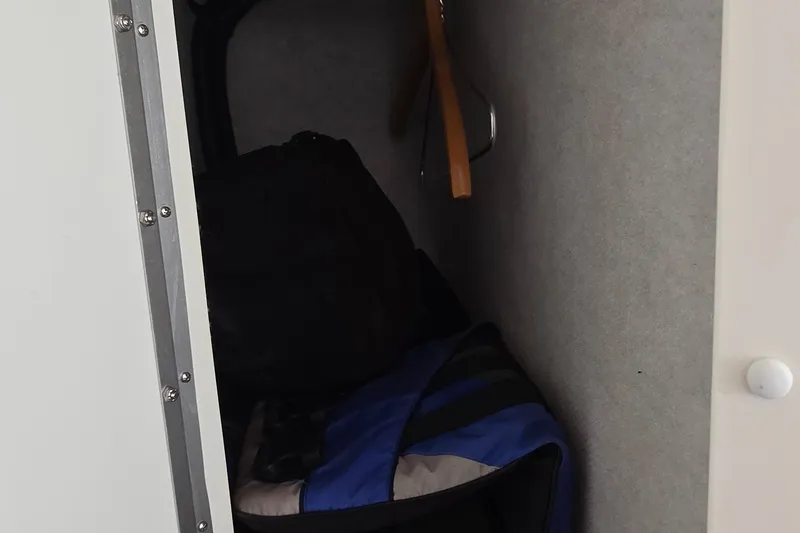 Slide: The Image of Storage compartment inside 2007 Fountain 42 Executioner boat, featuring bags and hangers. - 27