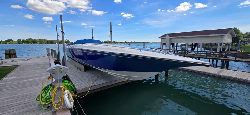 Slide: The Image of 2007 Fountain 42 Executioner speedboat docked by a serene lake under a clear blue sky. - 4