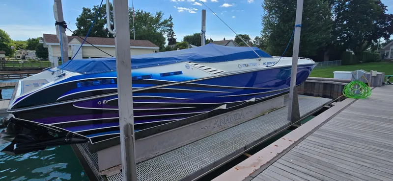 Slide: The Image of 2007 Fountain 42 Executioner speedboat docked with blue cover, vibrant design, and scenic background. - 5