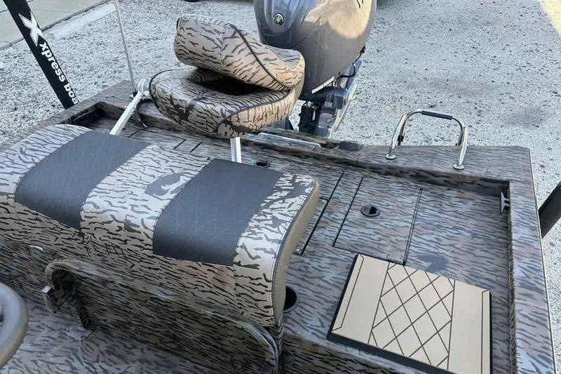 Slide: The Image of 2026 Xpress H210B boat interior with camouflage seating and motor, featuring a sleek design. - 14