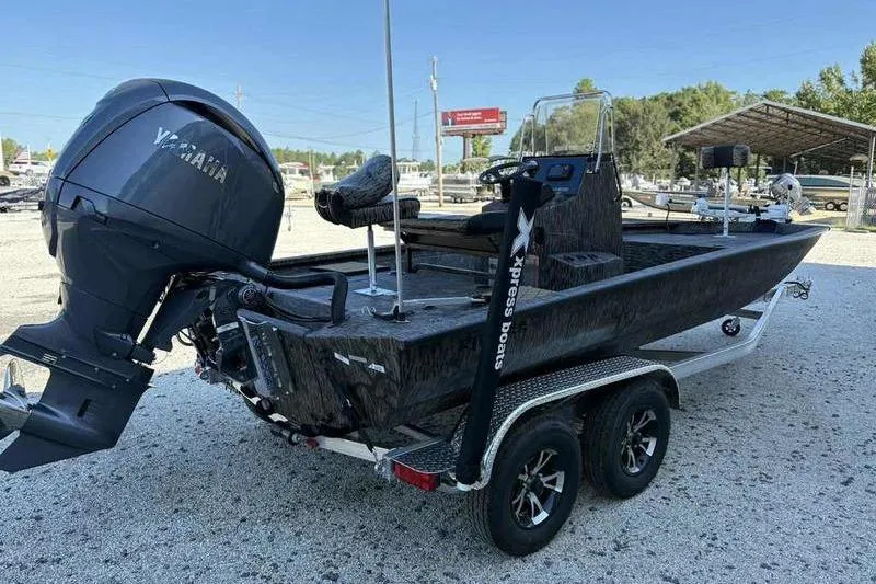 Slide: The Image of 2026 Xpress H210B boat with Yamaha engine on a trailer in a parking lot. - 2