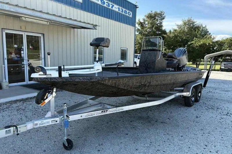 Slide: The Image of 2026 Xpress H210B boat on trailer outside dealership, featuring Minn Kota trolling motor. - 4