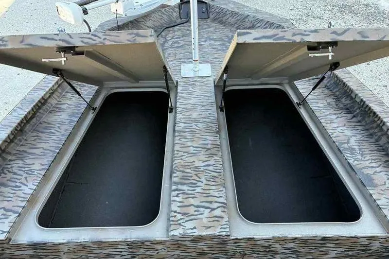 Slide: The Image of 2026 Xpress H210B boat with open storage compartments, featuring a camouflage pattern. - 7