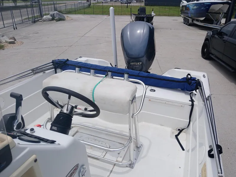 Slide: The Image of 2005 Skeeter ZX 2200 boat with steering console and outboard motor in a parking area. - 10