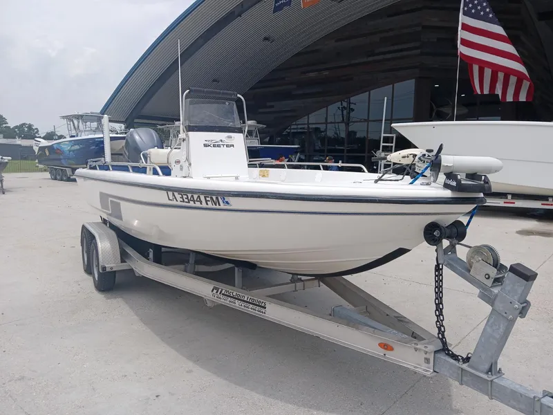 Slide: The Image of 2005 Skeeter ZX 2200 boat on trailer, parked outside dealership with American flag. - 6