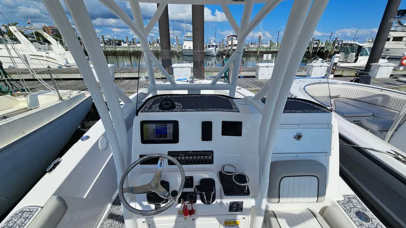 Slide: The Image of 2022 Sea Fox 249 Avenger boat dashboard with steering wheel and controls at marina. - 10