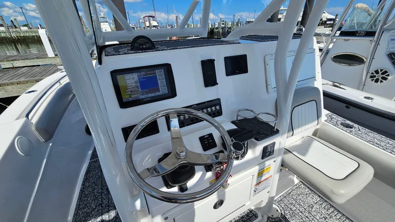 Slide: The Image of 2022 Sea Fox 249 Avenger boat dashboard with steering wheel and navigation display. - 11