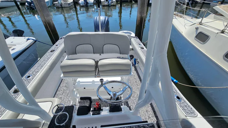 Slide: The Image of 2022 Sea Fox 249 Avenger boat interior with dual seating and steering wheel at marina. - 18