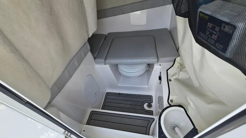 Slide: The Image of 2022 Sea Fox 249 Avenger boat interior with compact toilet and seating area. - 19