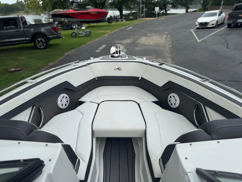 Slide: The Image of 2022 Monterey 278SS Super Sport boat interior with white seating and speakers, parked near a lake. - 8
