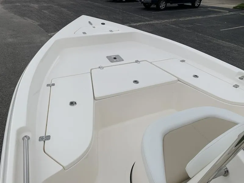 Slide: The Image of 2026 Bulls Bay 2000 boat console with steering wheel and controls, docked outdoors. - 18