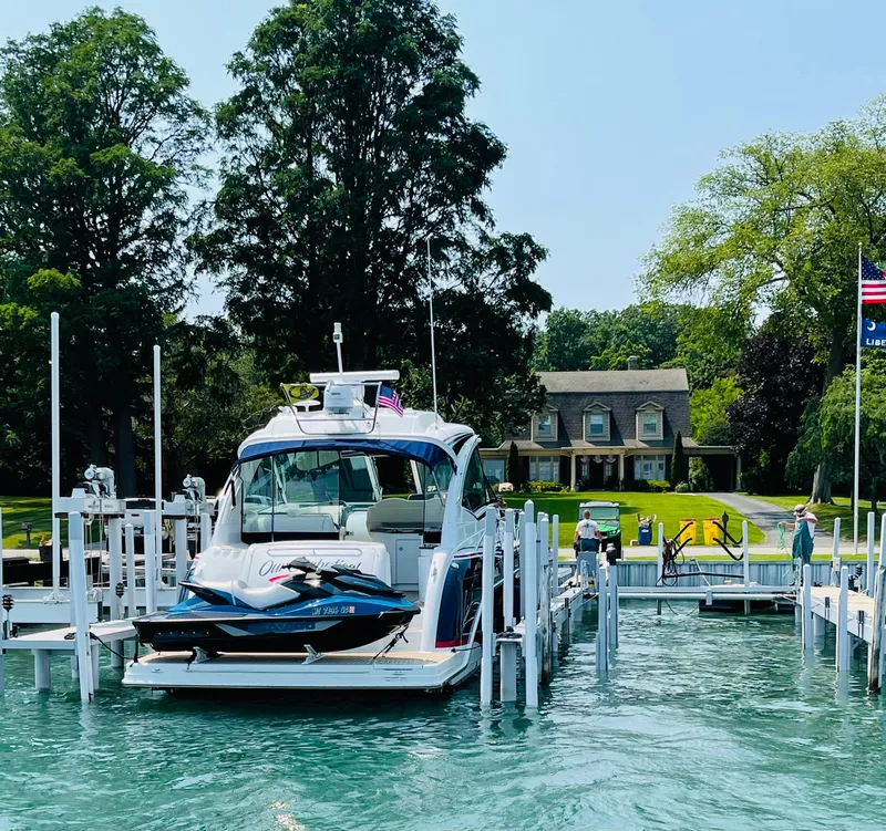 Slide: The Image of 2014 Formula 45 Yacht docked at a marina with a scenic lakeside house. - 14