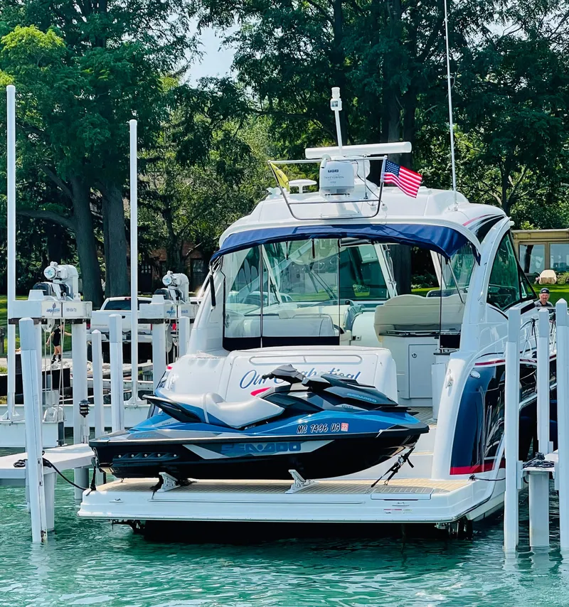 Slide: The Image of 2014 Formula 45 Yacht docked with jet ski on platform, surrounded by trees. - 15