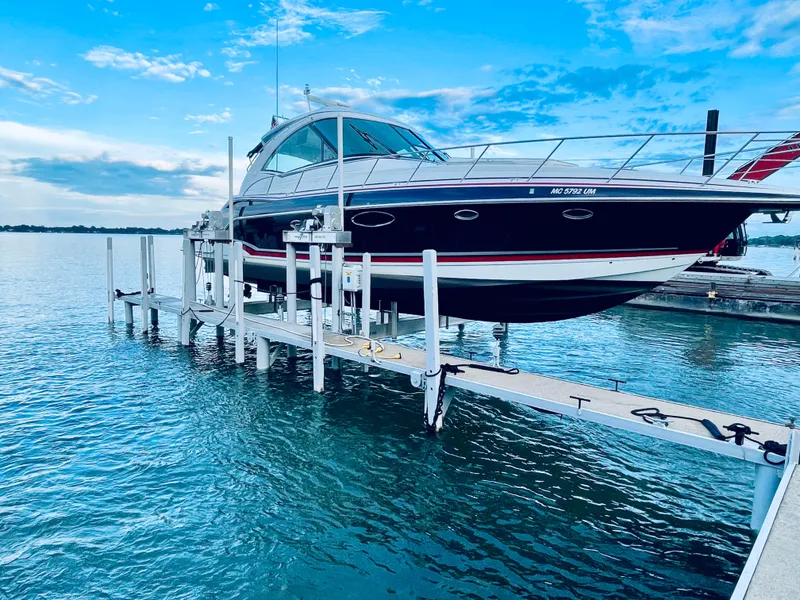 Slide: The Image of 2014 Formula 45 Yacht on lift, docked by serene blue waters under a partly cloudy sky. - 17