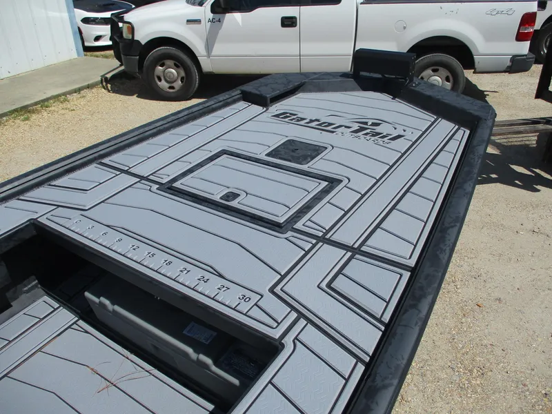 Slide: The Image of 2025 Gator Tail 2060 EXTREME boat deck with measurement markings, parked near trucks. - 11