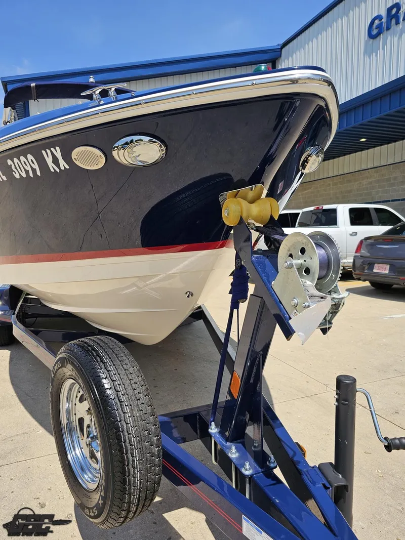 Slide: The Image of 2018 Regal 2300 Bowrider on trailer, parked outside a building on a sunny day. - 13