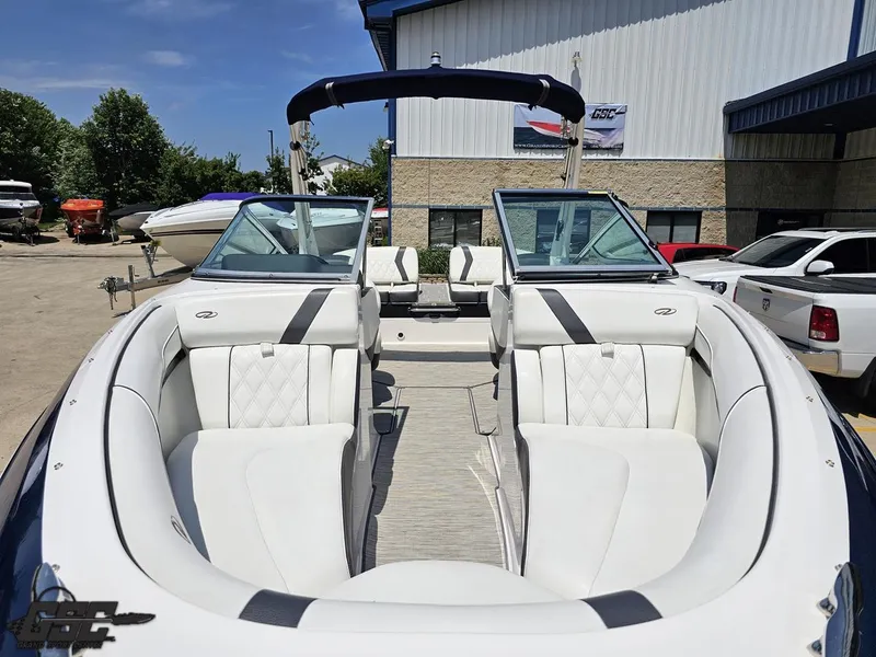 Slide: The Image of 2018 Regal 2300 Bowrider boat with white interior, parked outdoors near other boats. - 15