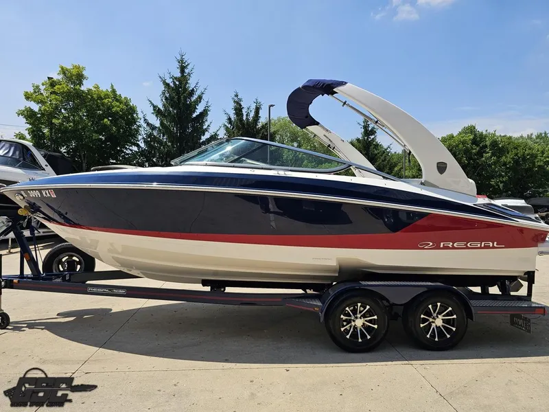 Slide: The Image of 2018 Regal 2300 Bowrider boat on trailer, parked outdoors, sunny day. - 20
