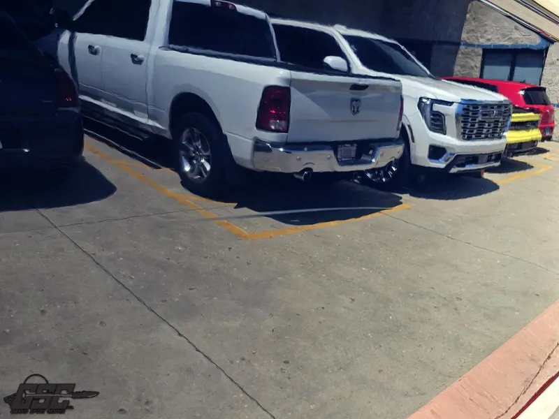 Slide: The Image of Parking lot with various vehicles, including a white truck and SUV, under bright sunlight. - 23
