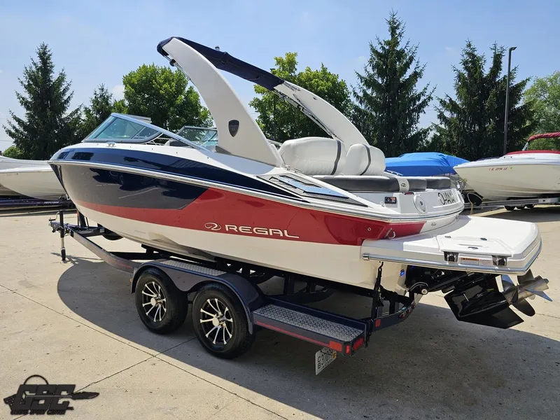 Slide: The Image of 2018 Regal 2300 Bowrider boat on trailer, red and white design, parked outdoors. - 27