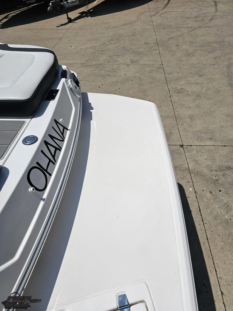 Slide: The Image of 2018 Regal 2300 Bowrider boat with "OHANA" name on the stern, docked on concrete. - 34