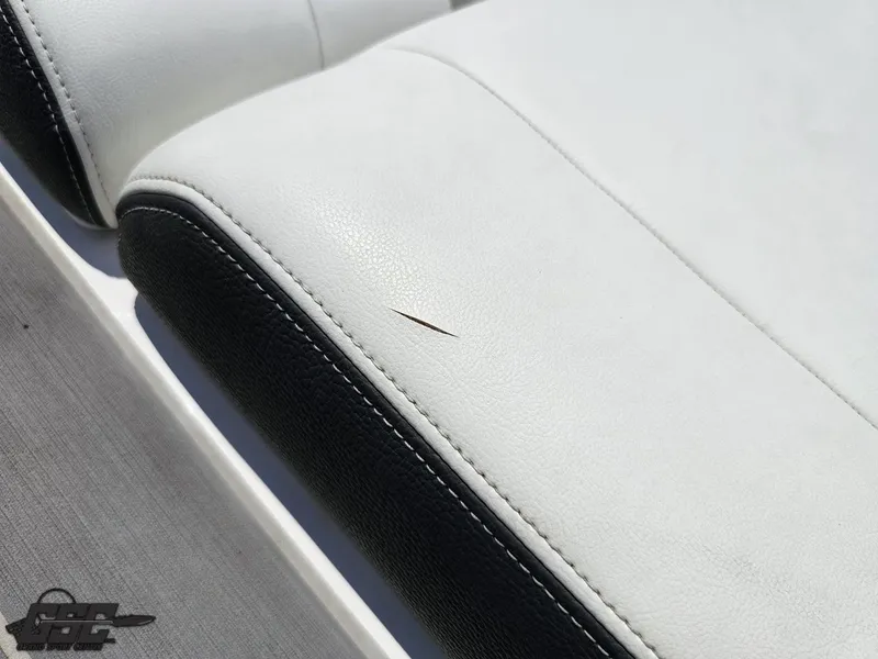 Slide: The Image of White and black upholstery with a small tear on a 2018 Regal 2300 Bowrider boat seat. - 46