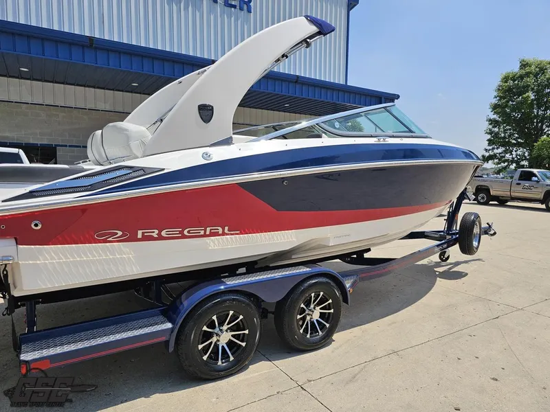 Slide: The Image of 2018 Regal 2300 Bowrider boat on trailer, parked outside a building. - 8