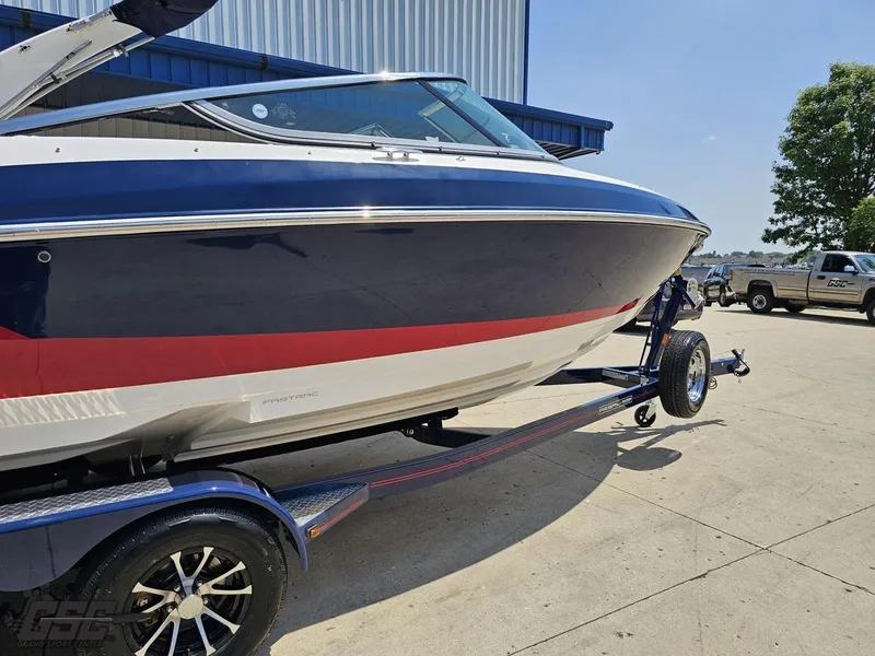 Slide: The Image of 2018 Regal 2300 Bowrider boat on trailer, parked outdoors near a building. - 9