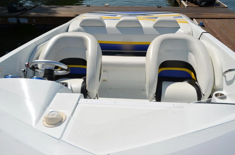 Slide: The Image of 2008 Baja 26 Outlaw boat interior with white and blue seating, docked by the water. - 10