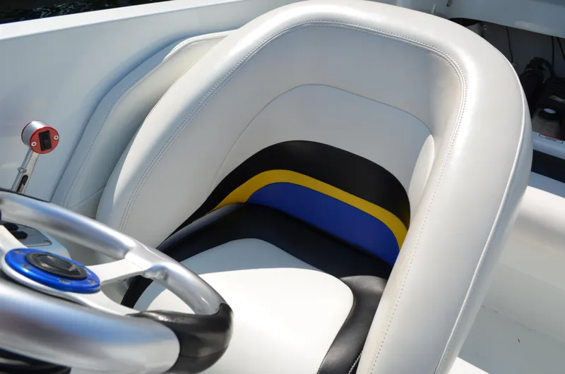 Slide: The Image of 2008 Baja 26 Outlaw boat interior with white, black, and blue seat and steering wheel. - 19