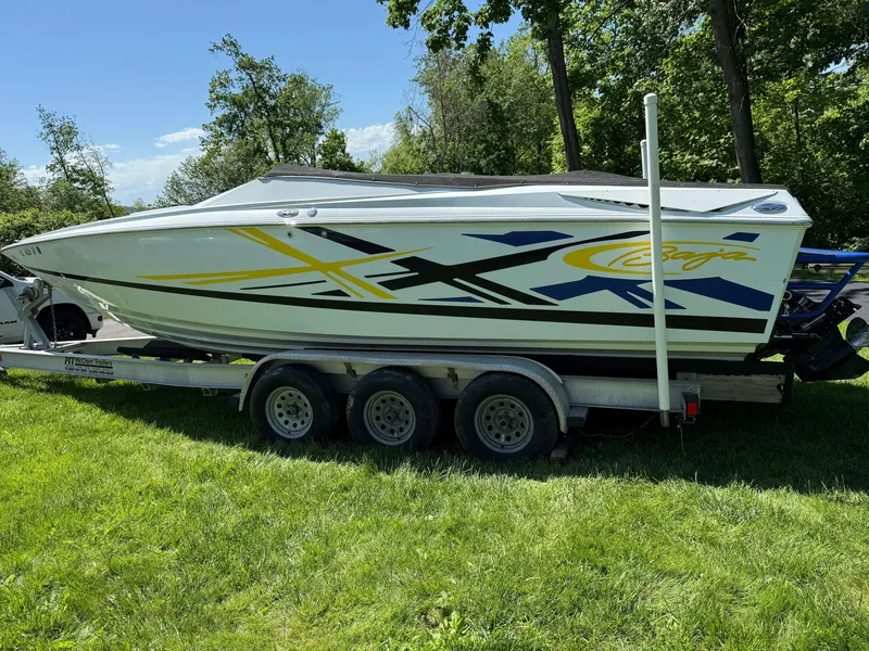 Slide: The Image of 2008 Baja 26 Outlaw boat on trailer, parked on grass, with vibrant graphics. - 35