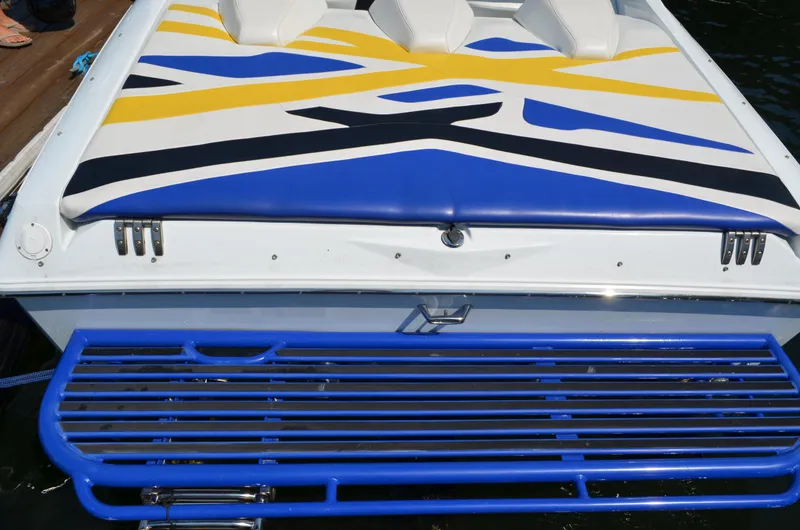 Slide: The Image of 2008 Baja 26 Outlaw boat with vibrant blue, yellow, and white design. - 2