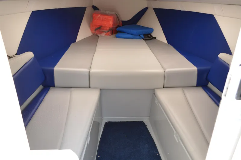 Slide: The Image of Interior cabin of a 2008 Baja 26 Outlaw boat with blue and gray seating. - 27