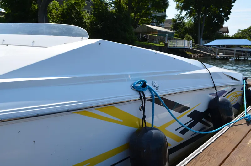 Slide: The Image of 2008 Baja 26 Outlaw boat docked with vibrant graphics and fenders. - 4