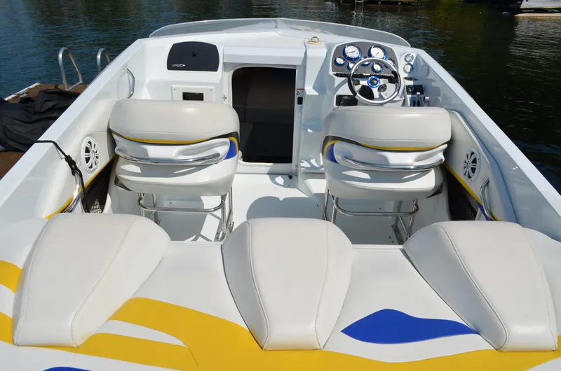 Slide: The Image of 2008 Baja 26 Outlaw boat interior with white and yellow seating, steering wheel, and dashboard. - 9